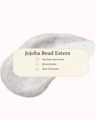 Close-up of exfoliating skincare texture with visible Jojoba Bead Esters. Overlaid text highlights benefits: texture smoothing, brightening, and skin turnover. Visual emphasizes gentle physical exfoliation for radiant, even skin—ideal for sensitive, acne-prone skin types.